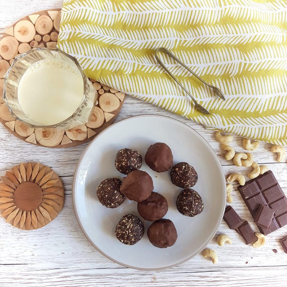 Gluten Free Ginger Bliss Balls on a plate with a glass of soya milk